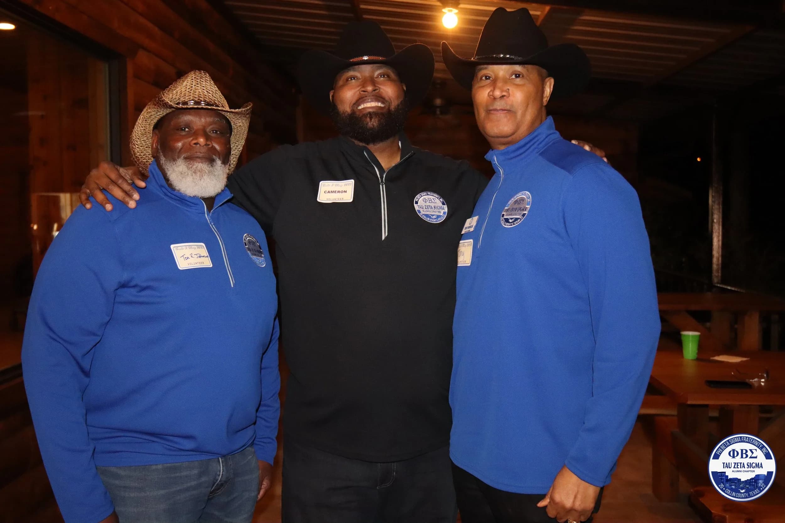 Three Tau Zeta Sigma brothers in blue chapter gear at a social event