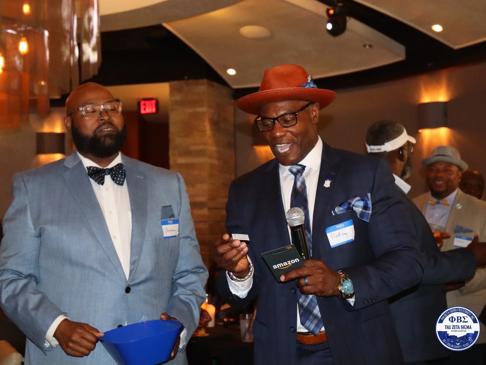 Brothers speaking to guests at a chapter fundraiser